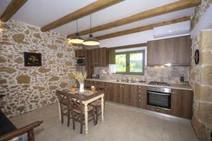 a kitchen with wooden cabinets and a table at Pamelas House with Jacuzzi in Kissamos