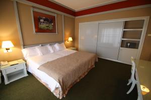 a hotel room with a large bed and two lamps at Printania Palace Hotel in Broummana