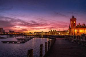 a city with a clock tower and a building with a clock at Yugo Explore - Arofan House in Cardiff +7 photos