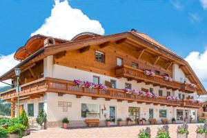 un grande edificio in legno con fiori sul balcone di Hotel Alpenrose Dolomites a La Valle