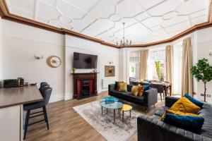ein Wohnzimmer mit Sofas und einem Tisch in der Unterkunft 3 Bedroom Garden Apartment Opposite the Beach in Brighton & Hove