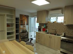 a kitchen with wooden cabinets and a table and a sink at Arman Group Basement Loft in Athens