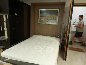a man walking into a bedroom with a bed at Arman Group Basement Loft in Athens
