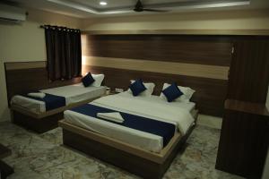 a bedroom with two beds with blue pillows at HOTEL BEST BUY in Kolkata