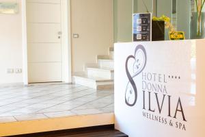 a sign for a hotel domina livina in a lobby at AHG Donna Silvia Wellness Hotel in Manerba del Garda