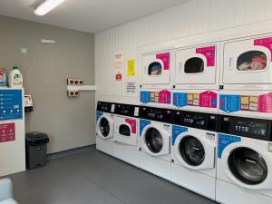 a laundry room with four washers and a row thereof at Yugo Explore - Arofan House in Cardiff
