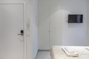 1 dormitorio con 1 cama y TV en la pared en Comfortable Room close to City Centre, en Valencia