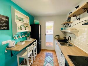 Kuchnia z niebieskimi ścianami i czarną lodówką w obiekcie Apartamento Rural La Leyenda w mieście El Bosque
