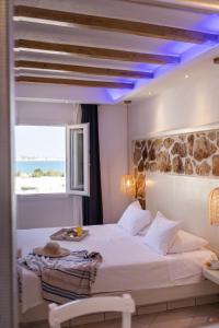 a bedroom with a large white bed with a blue ceiling at Mikri Vigla Hotel Beach Resort in Mikri Vigla
