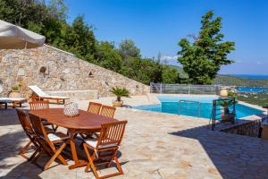 un patio con mesa y sillas junto a una piscina en Epidavros Land villa Antigoni, en Palaia Epidavros