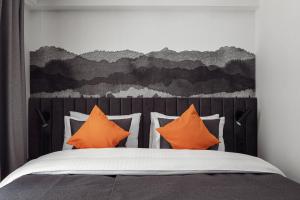 um quarto com uma cama com almofadas laranja em Dlouha Apartments Old Town Prague em Praga