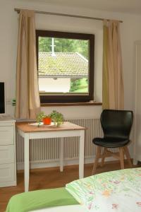 1 dormitorio con mesa, silla y ventana en Das kleine Paradies en Unken