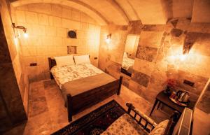 a small room with a bed in a stone wall at The Cave House in Urgup