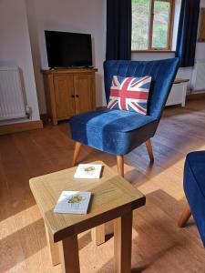 a living room with a blue chair and a coffee table at The Old Smithy Bed & Breakfast in Craven Arms