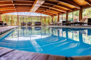 an indoor swimming pool with blue water in a house at Hotel SPA Plage St Jean in La Ciotat