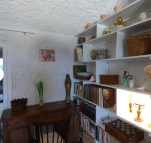 a room with a desk and shelves with books at CASA SUPRA U MARE in Centuri
