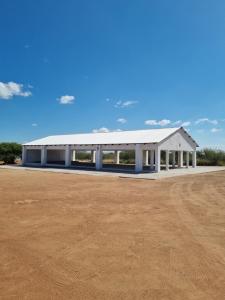 Un gran edificio blanco en un campo de tierra. en Ribeng la Noka Conference and Leisure Center, en Ga-Ramokadi-kadi