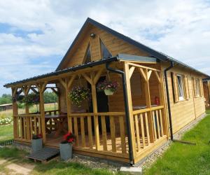 a wooden cabin with a gazebo at Na polance dwa domki in Chłopy