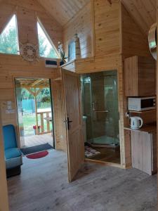 a large wooden cabin with a glass shower in it at Na polance dwa domki in Chłopy