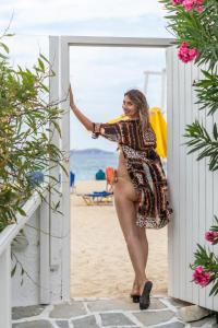 Mikri Vigla Hotel Beach Resort في ميكري فيغلا: امرأة تقف في مدخل على الشاطئ