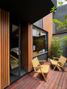 a patio with two chairs and a bed in a building at The Nhorm Hotel Ratchada in Bangkok