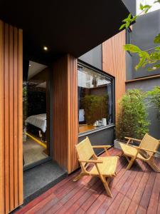 a patio with two chairs and a bed in a building at The Nhorm Hotel Ratchada in Bangkok