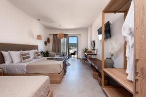 Del Mare Suites في غيلفا: غرفه فندقيه سريرين وتلفزيون