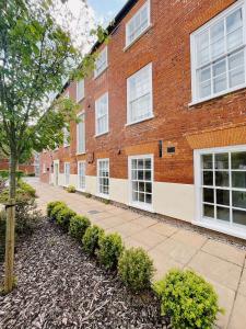 een bakstenen gebouw met witte ramen en een stoep bij 73A Weavers House - Mountergate in Norwich