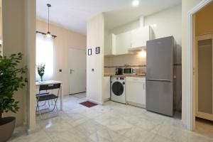 cocina con lavadora y mesa en una habitación en Apartamentos Tejares de Triana 16B, en Sevilla