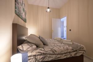 Un dormitorio con una cama con almohadas. en Apartamentos Tejares de Triana 16B, en Sevilla