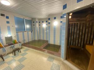 Hotel Tetora HonHachinohe في هاتشينوه: حمام كبير مع حوض في الغرفة