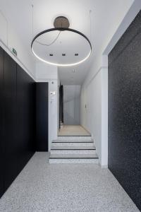 a hallway with stairs and a large light fixture at Filopappou Hill Suites by Athens Stay in Athens