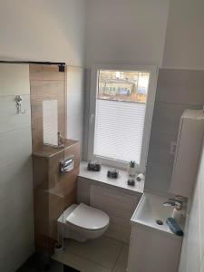niewielka łazienka z toaletą i oknem w obiekcie Willa Andersa w mieście Ruciane-Nida