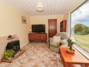 a living room with a fireplace and a tv at Broadstones in Bridport