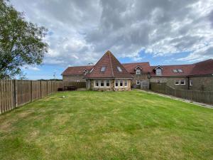 a house with a large yard with a fence at The Roundal in Crail