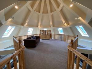 an attic room with a couch in the middle at The Roundal in Crail