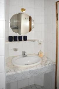 Un baño blanco con lavabo y espejo. en Gästehaus Nigg, en Eisenberg