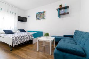 a living room with a couch and a bed at La Casa de Silvia Visita Parque Warner, Madrid y alrededores in San Martín de la Vega