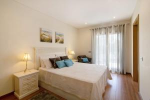 a bedroom with a bed with a white bedspread at Varandas do Sol - Olhos de Água in Albufeira +20 photos