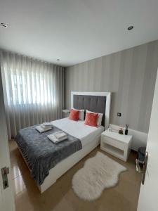 um quarto com uma grande cama branca com almofadas vermelhas em OPORTO House AL em Maia