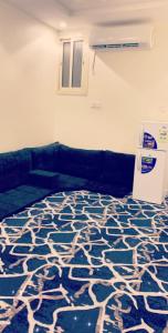 a room with a blue and white carpet with a refrigerator at شقق العزاب الفاخرة in Tabuk