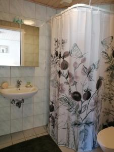 y baño con cortina de ducha y lavamanos. en Gjern B&B, en Gjern