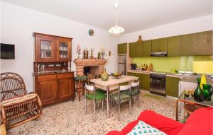 une cuisine avec des armoires vertes, une table et des chaises dans l'établissement Beautiful Home In Ficulle With Kitchenette, à Ficulle