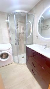 een badkamer met een douche, een wastafel en een wasmachine bij Moxo in Empuriabrava
