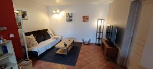 a living room with a couch and a tv at Mas Christiane in Buis-les-Baronnies