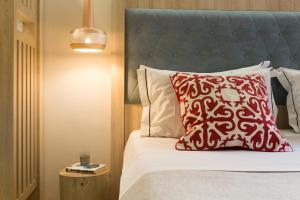 a bed with a red pillow and a blue headboard at C Suites in Rethymno