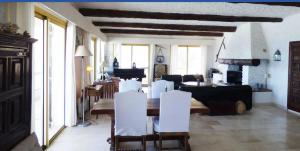 a living room with a table and white chairs at CASA SUPRA U MARE in Centuri