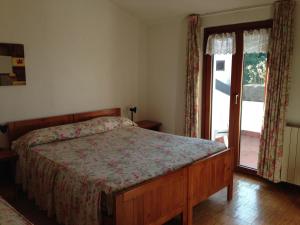 1 dormitorio con 1 cama y puerta corredera de cristal en Hotel Marcellino, en Selvino