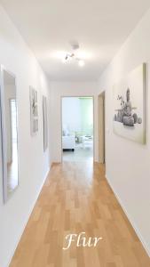 a living room with white walls and a wooden floor at Ferienwohnung Pagel in Riedenburg