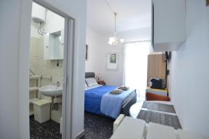 a bedroom with a bed and a sink and a mirror at B&B CASAVACANZE CHIESA MADRE in Carovigno